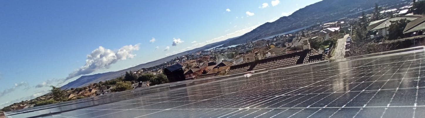 Placas solares embalse y castillo paneles solares con casas y montaña al fondo